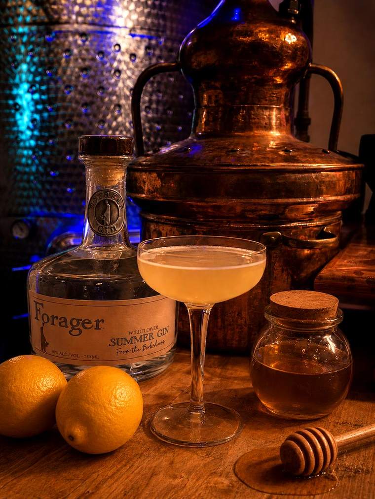 A Summer Gin cocktail beside the miniature copper still